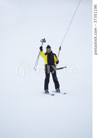 Happy skier using T-bar ski drag lift 37301196