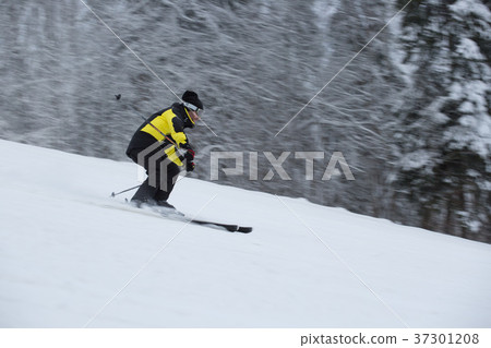 Skier on piste running downhill Skier on piste running downhill 37301208