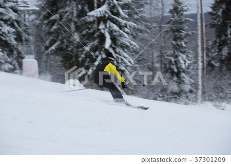 Skier on piste running downhill Skier on piste running downhill 37301209