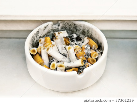 Heap of cigarette butts in a ashtray. 37301239