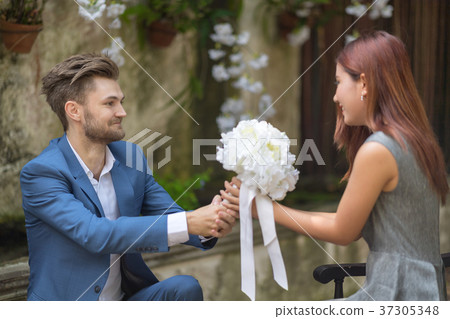 Young man giving bouquet of flowers to girlfriend. Young man giving bouquet of flowers to girlfriend. 37305348