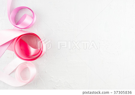 White textured background with pink satin ribbons White textured background with pink satin ribbons 37305836