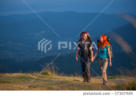 Young couple tourists traveling in the mountains Young couple tourists traveling in the mountains 37307489
