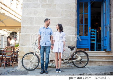 Guy and girl near tandem bike, walls and vintage door 37308100