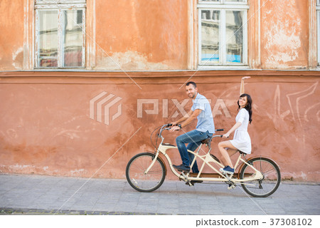 Young couple on tandem bicycle at the street city 37308102