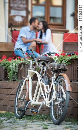 Retro tandem bicycle near red flowers 37308113