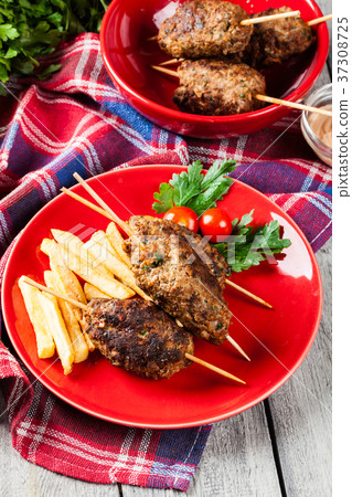 Barbecued kofta with fries on a plate 37308725