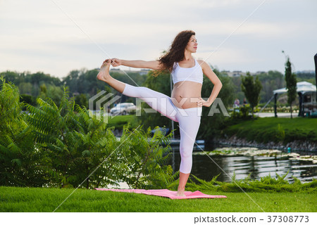 Pregnant woman doing prenatal yoga on nature. 37308773