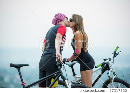 Romantic young couple kissing on bicycles 37317360