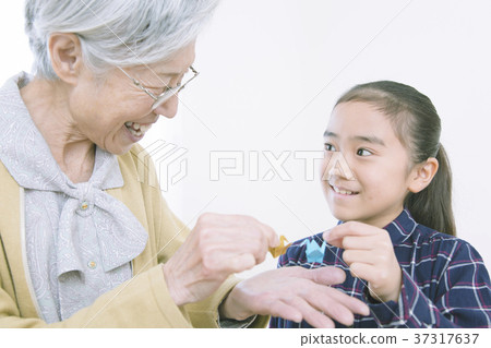 Grandma and girl folding origami Grandma and girl folding origami 37317637