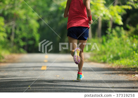 woman runner running on tropical forest trail 37319258