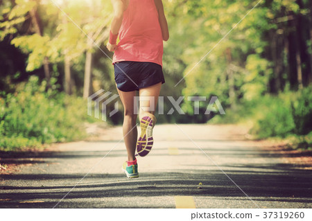 woman runner running on tropical forest trail 37319260