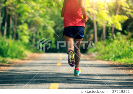 woman runner running on tropical forest trail 37319261