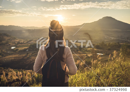 Young woman traveler looking at sunrise Young woman traveler looking at sunrise 37324998