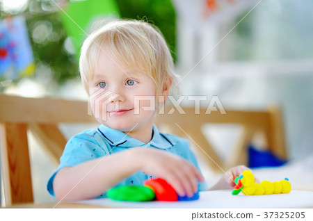 Creative boy playing with colorful modeling clay at kindergarten Creative boy playing with colorful modeling clay at kindergarten 37325205