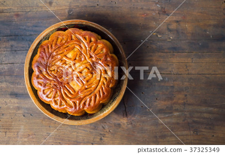 Traditional moon cake on wooden background Traditional moon cake on wooden background 37325349