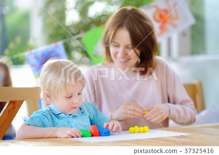Cute little boy drawing and painting with colorful markers pens at kindergarten Cute little boy drawing and painting with colorful markers pens at kindergarten 37325416
