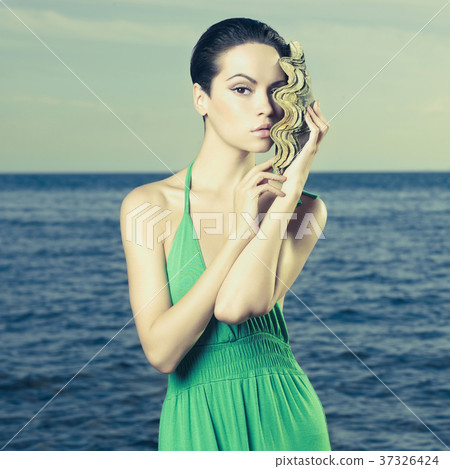Beautiful lady with large sea shell 37326424
