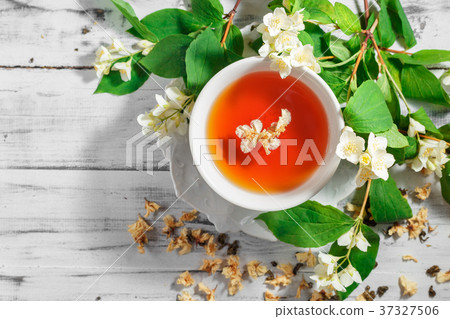 Cup of green tea with jasmine flowers Cup of green tea with jasmine flowers 37327506