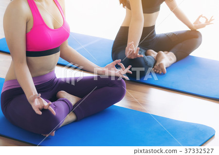 Women doing yoga lotus pose in fitness gym class 37332527