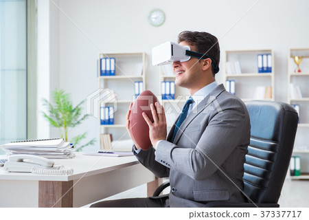 Businessman playing virtual reality football in Businessman playing virtual reality football in 37337717