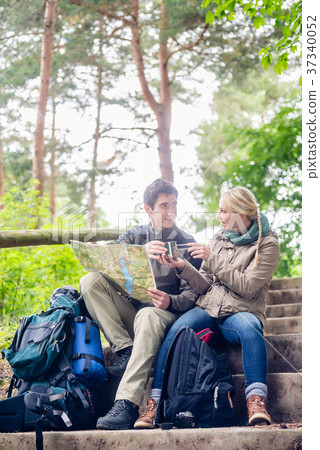 Hiking couple having break on forest trail  37340052