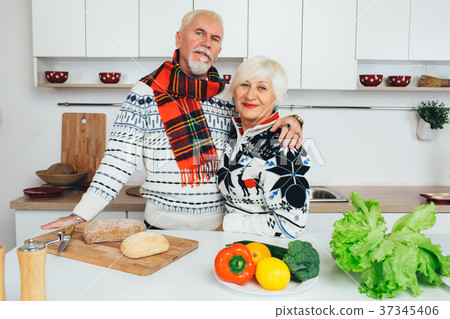 elderly couple embracing in the kitchen 37345406