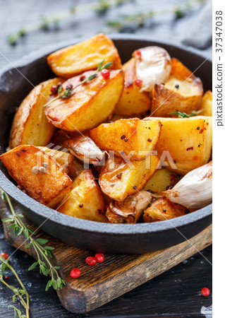 Potato slices baked with garlic, pepper and thyme. 37347038