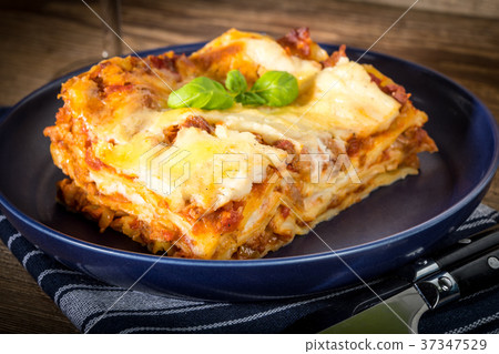 Piece of tasty hot lasagna with red wine. Piece of tasty hot lasagna with red wine. 37347529