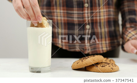 woman cookie dipping warm milk snack woman cookie dipping warm milk snack 37347541