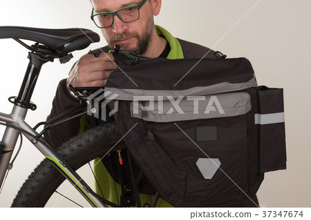 Man inserts bike carrier bag on rear rack of bike 37347674