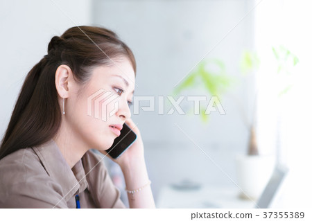 Young woman making a call by the window Young woman making a call by the window 37355389