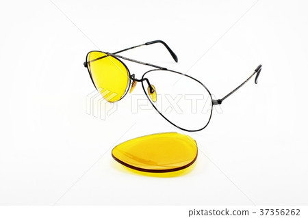 Broken yellow sunglasses lens on white background 37356262