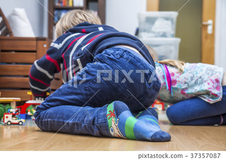 Two little kids playing with bricks on the floor 37357087
