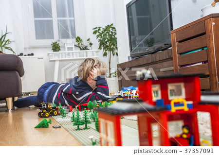 Little boy playing with bricks on the floor 37357091