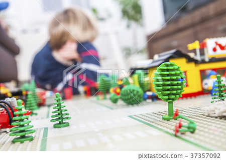 Little boy playing with bricks on the floor 37357092