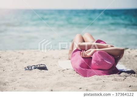 Woman in hat relaxing on beach 37364122