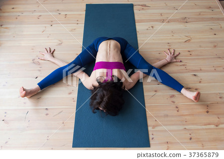 Top view of female yogi doing advanced kurmasana 37365879