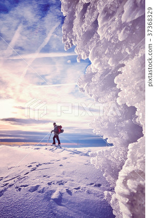 Ice formations with skier silhouette in distance. 37368329