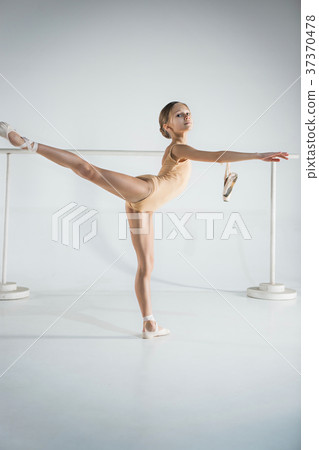 The girl is training near the ballet barre. 37370478