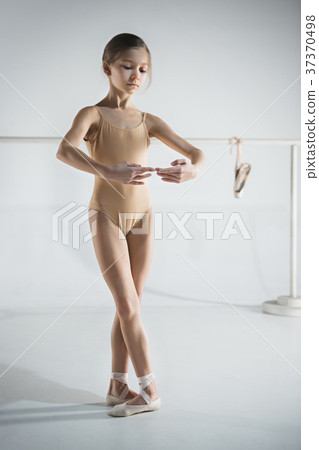 The girl is training near the ballet barre. 37370498