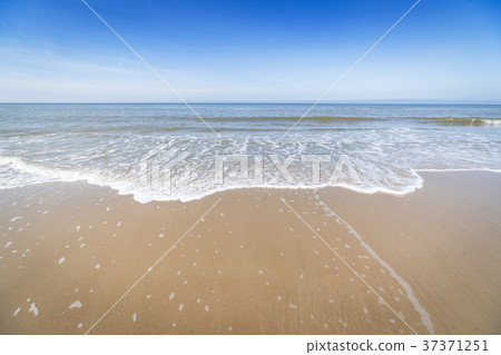Beach with small waves coming in on the shore Beach with small waves coming in on the shore 37371251