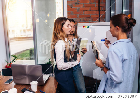 Three young businesswomen sharing new business Three young businesswomen sharing new business 37373397