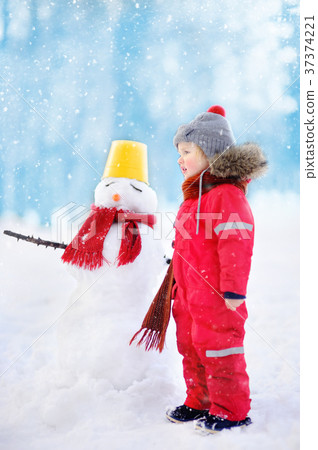 Kid during stroll in a snowy winter park Kid during stroll in a snowy winter park 37374221
