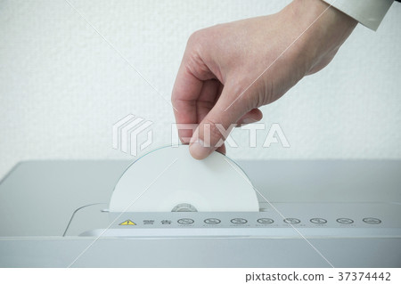 Businessman hand putting CD on shredder 37374442