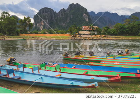 long tail boats on sunset at Song river, Vang Vien long tail boats on sunset at Song river, Vang Vien 37378223