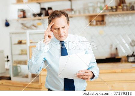 Thoughtful busy man overlooking documents and Thoughtful busy man overlooking documents and 37379318
