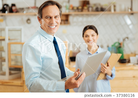 Pleasant confident man standing and holding the 37380116