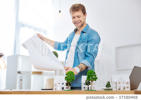 Satisfied engineer smiling while holding a big 37380408