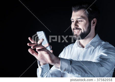 Delighted young man using his device Delighted young man using his device 37382058